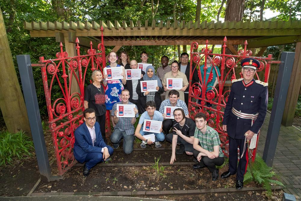 Graduates from Steps at Strawberry Field programmes celebrate at the iconic red gates
