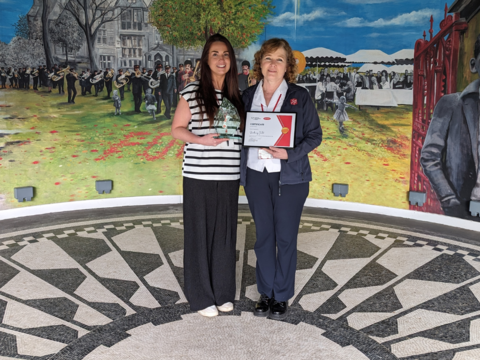 Lynne Furlong and Kathy Versfield stand on the bandstand holding the UniTemps LJMU External Engagement of the Year Award